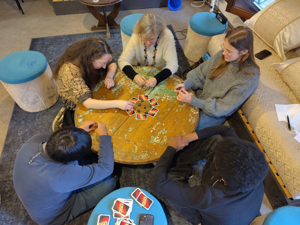 Quatre personnes jouent à un jeu d'aimants sur une table basse au Café Monde.